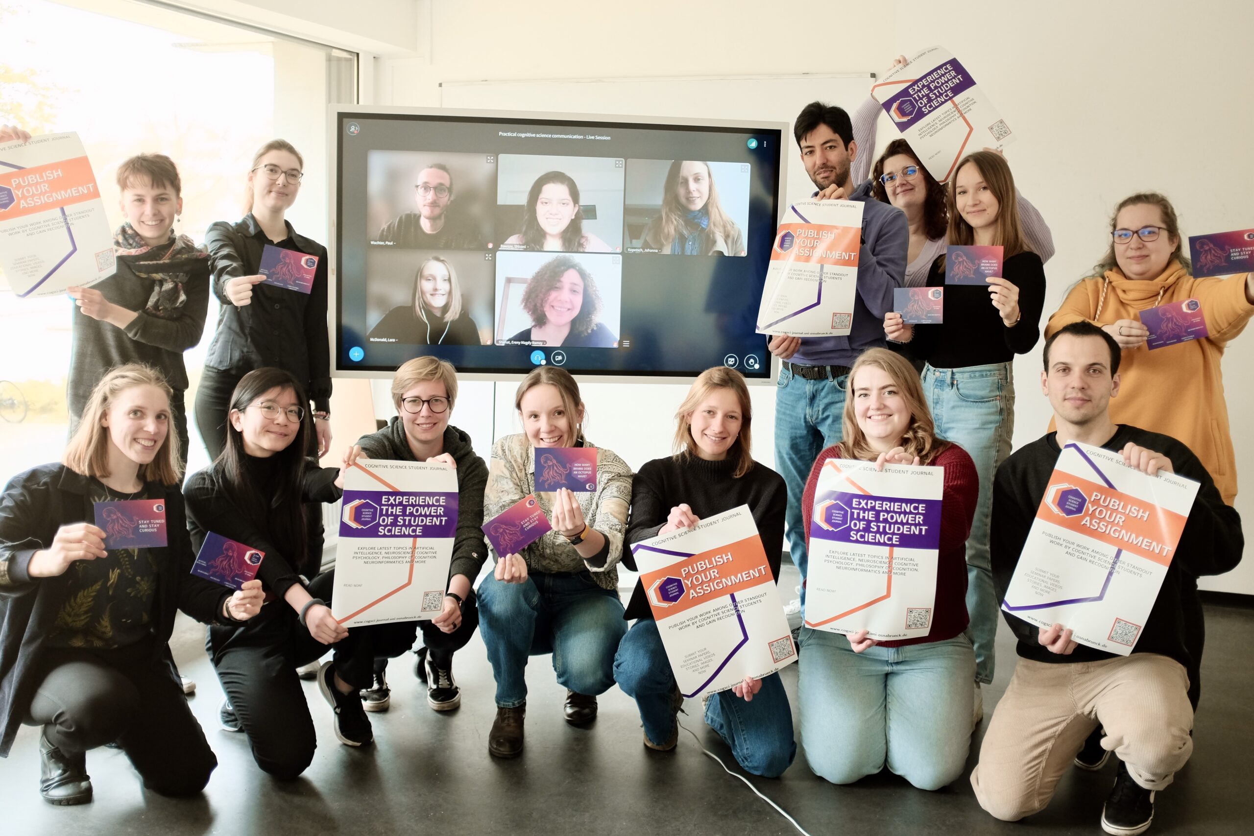 Picture of the student journal members 2023 with posters and postcards in their hands